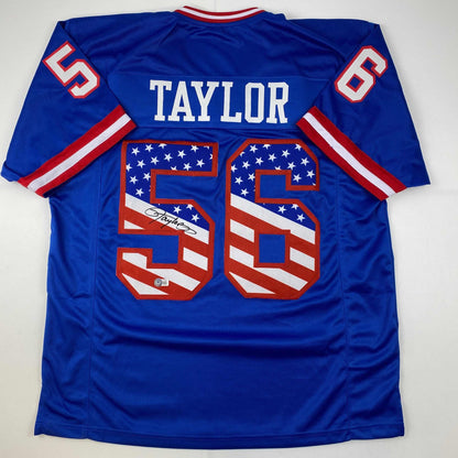 Autographed/Signed Lawrence Taylor New York Blue USA American Flag Football Jersey Beckett BAS COA