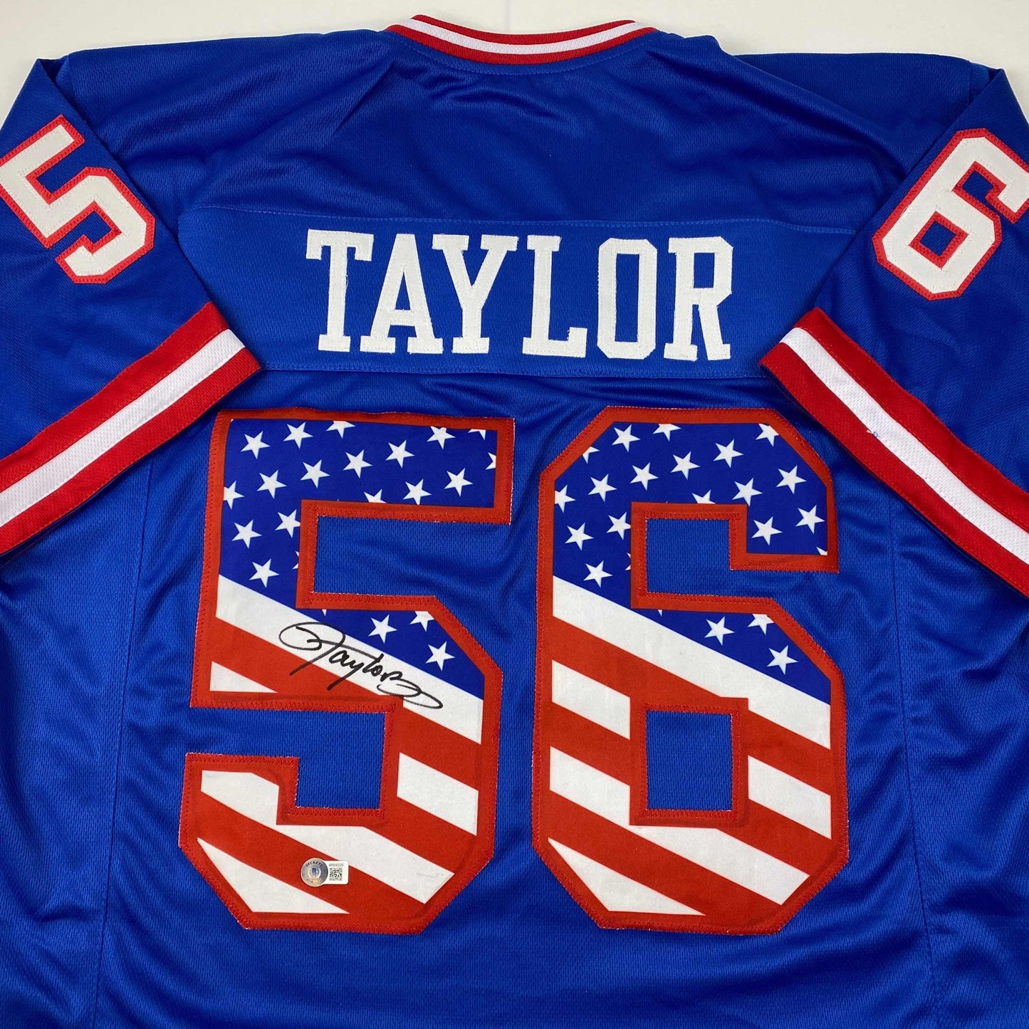 Autographed/Signed Lawrence Taylor New York Blue USA American Flag Football Jersey Beckett BAS COA