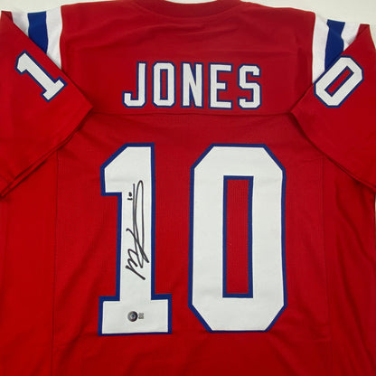 Autographed/Signed Mac Jones New England Red Football Jersey Beckett BAS COA